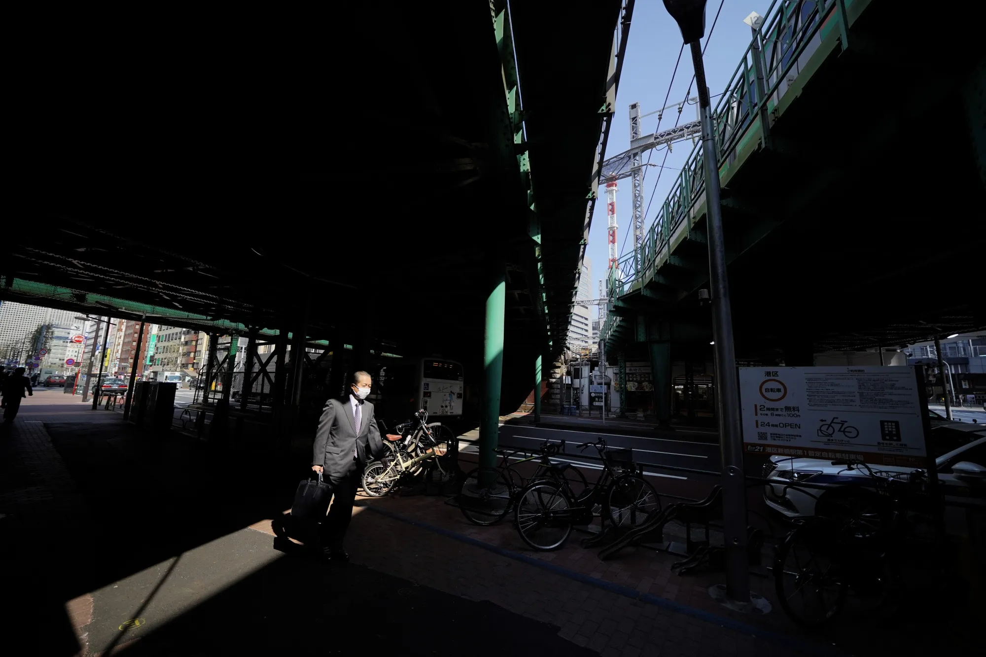 A pedestrian wearing a protective mask walks in the Shimbashi business district in Tokyo, April 8.