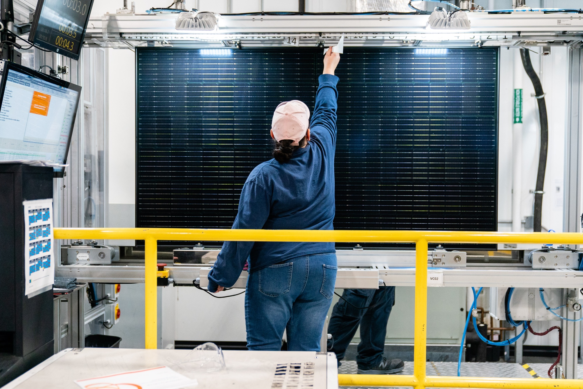 A quality control worker checks a solar panel at the Hanwha QCells manufacturing facility in Dalton.