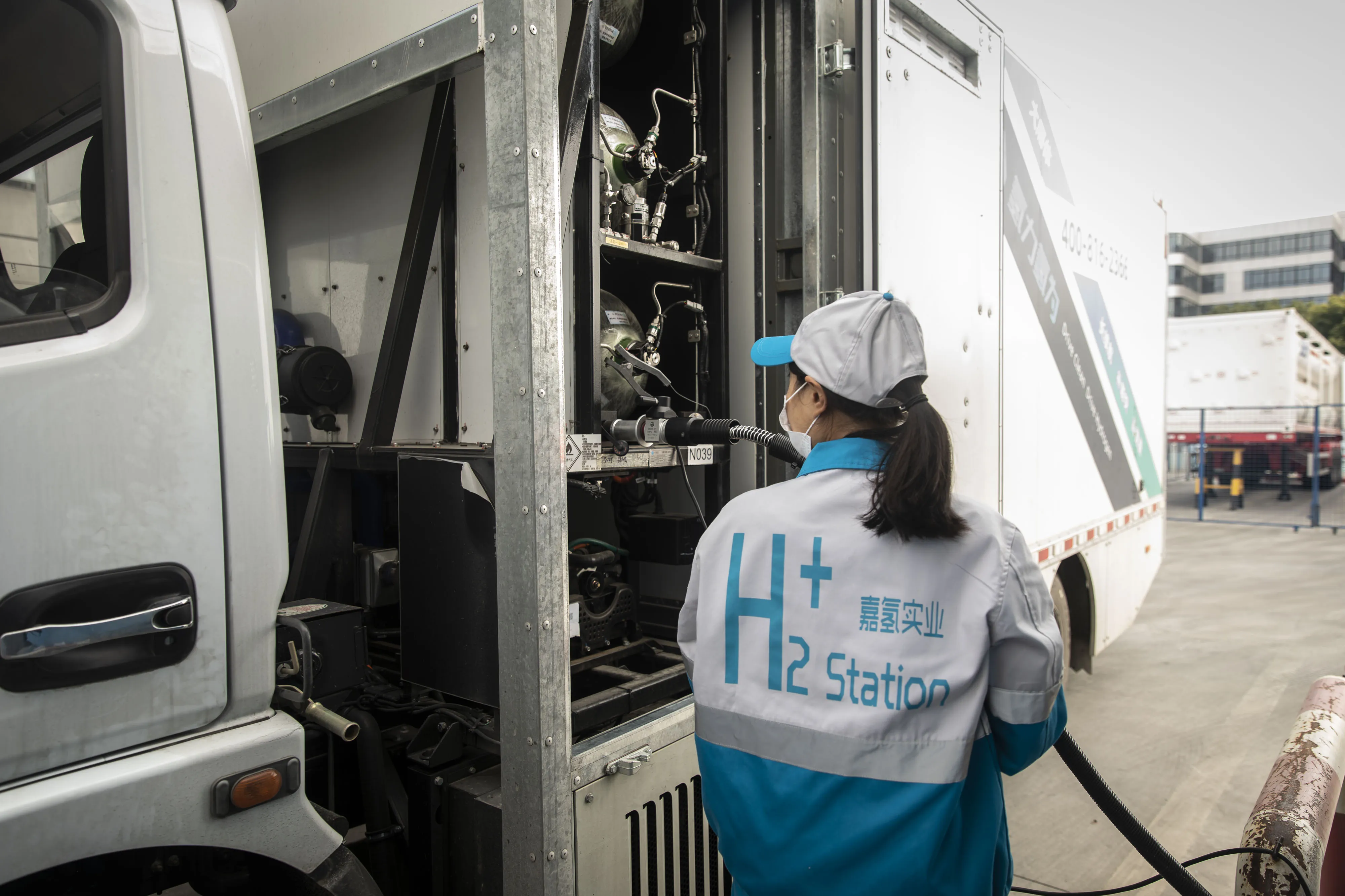 An attendant fills up a truck with compressed hydrogen at a filling station in Shanghai.