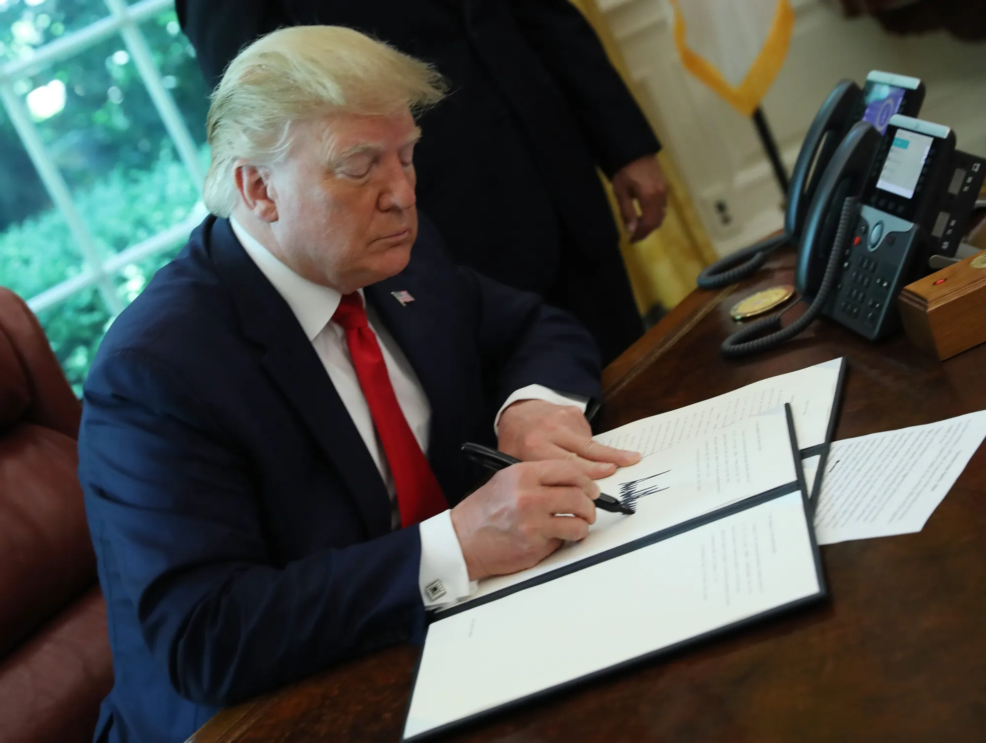 U.S. President Trump signs an executive order imposing sanctions on Iran in June 2019.