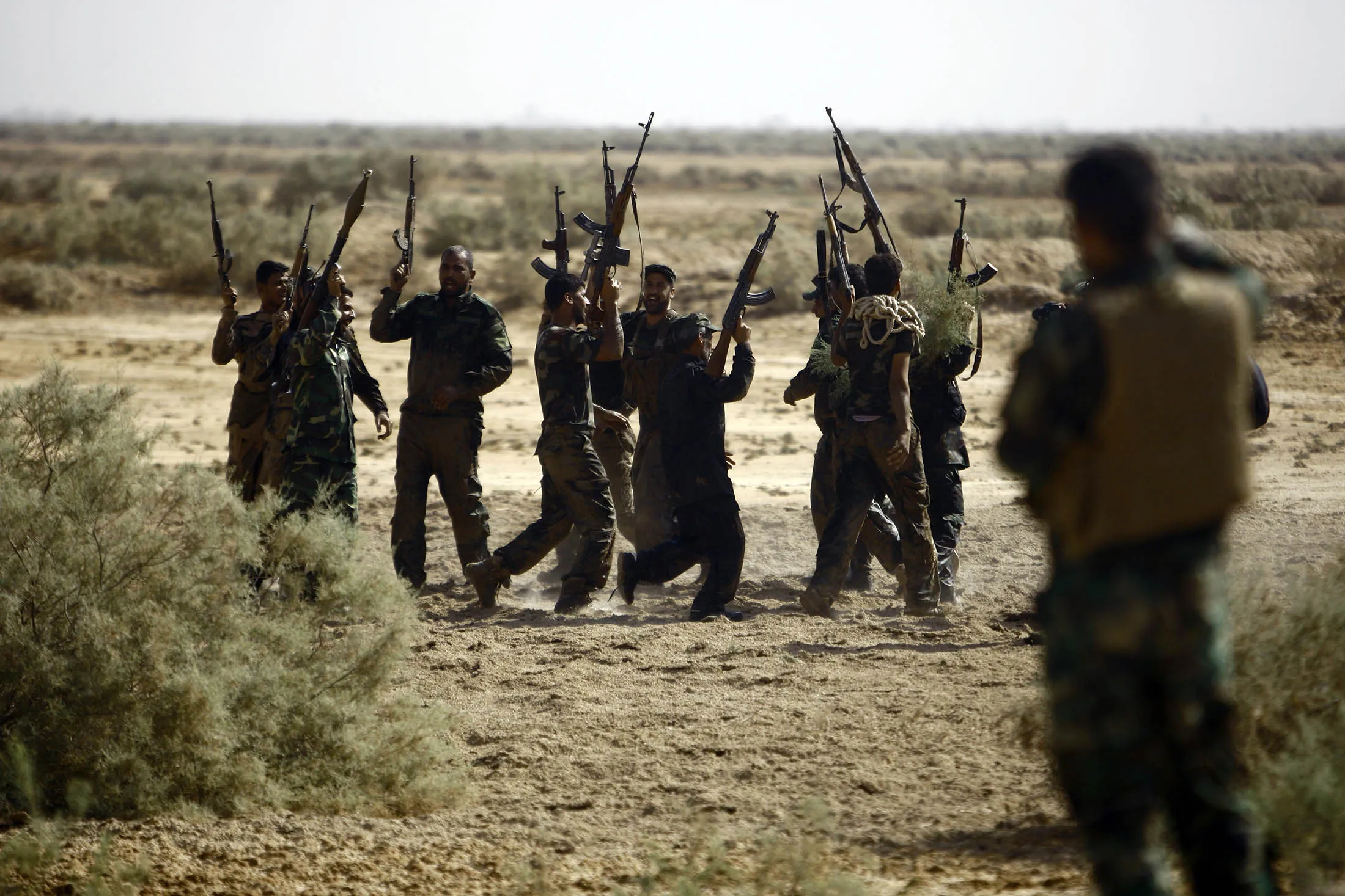 Shiite Muslim fighters, loyal to Iraqi Shiite cleric Moqtada al-Sadr, take part in a last combat training near the city of Najaf on August 23, 2014, before joining the government forces to fight Islamic State (IS) jihadists in the Jurf al-Sakhr area, south of Baghdad. Iraqi officials worked to calm soaring tensions after the killing of 70 people at a Sunni mosque, as Washington branded the beheading of an American journalist a 'terrorist attack.' AFP PHOTO / HAIDAR HAMDANI (Photo credit should read HAIDAR HAMDANI/AFP/Getty Images)
