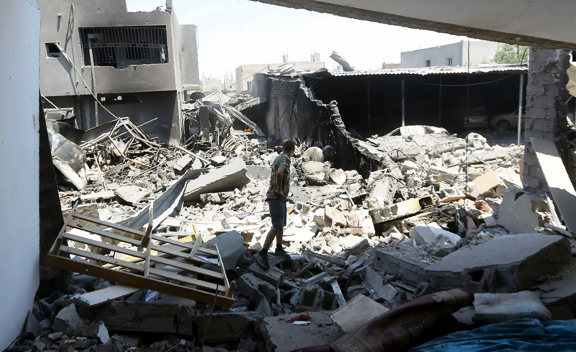 A fighter checks a building near the the Yarmouk military compound, south of Tripoli on July 1, 2019.