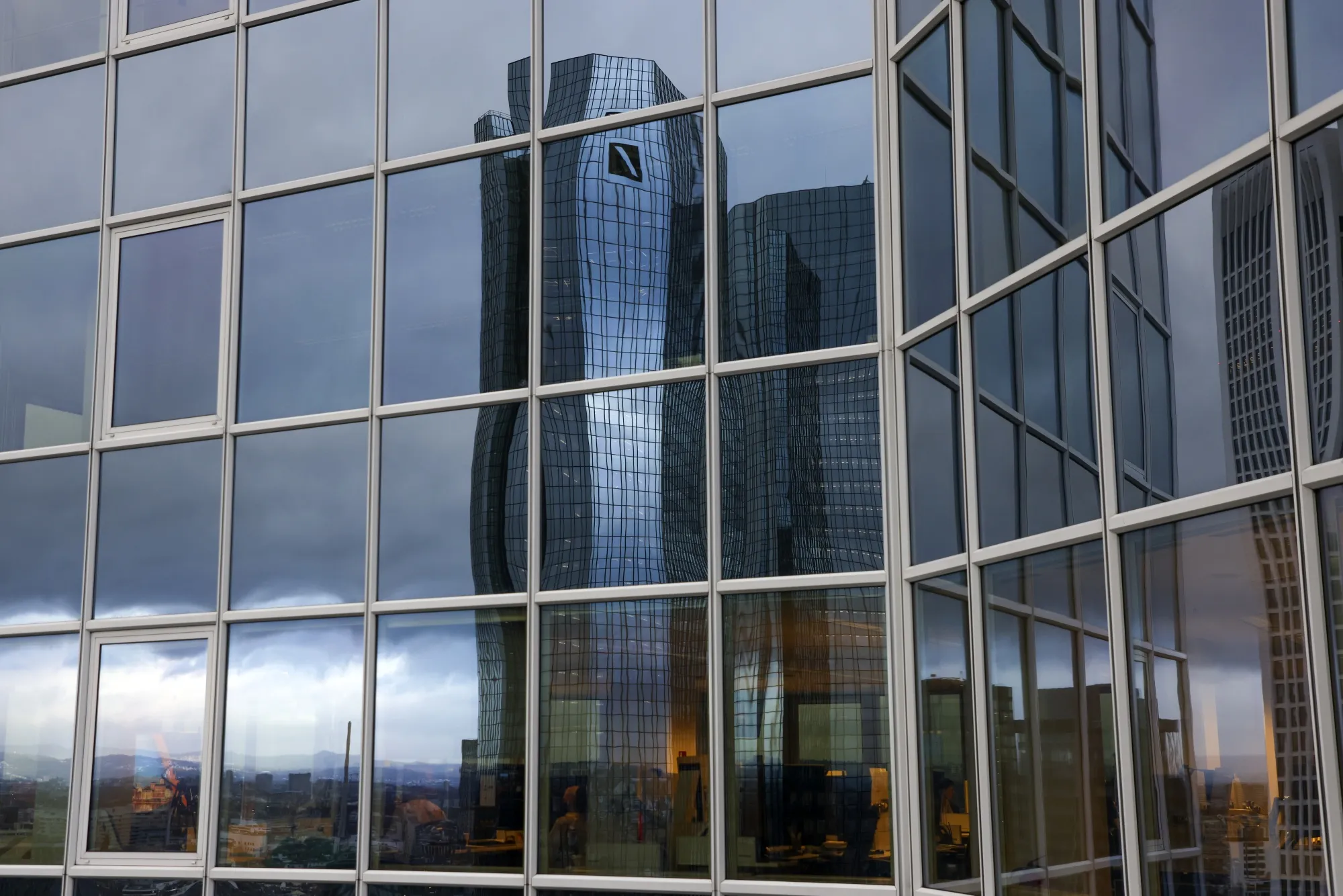The headquarters of Deutsche Bank AG reflected in the windows of an office building in Frankfurt