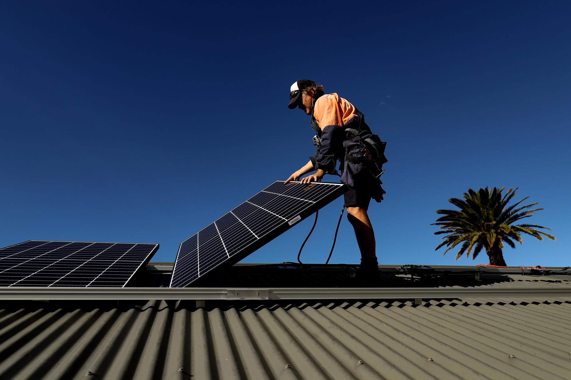 A Solarpro employee installs LG Electronics Inc. NeON R 370W solar panels onto the rooftop of a residential property in Sydney, Australia, on Monday, May 17, 2021. Australia is the global leader in generating electricity from the sun. Some 27% of buildings had a solar system on their roof at the end of 2020, the highest proportion in the world, according to figures from BNEF. Photographer: Brendon Thorne/Bloomberg