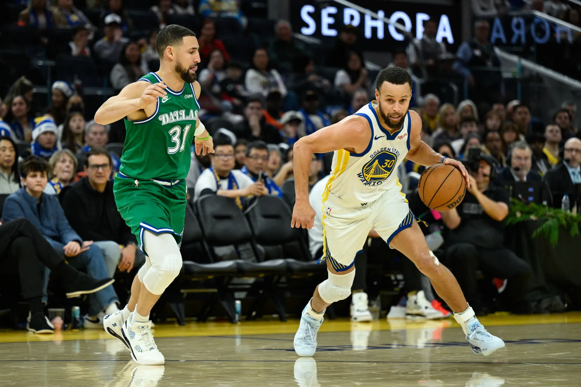 Golden State Warriors guard Stephen Curry dribbles against Dallas Mavericks Klay Thompson in San Francisco on Dec. 25.
