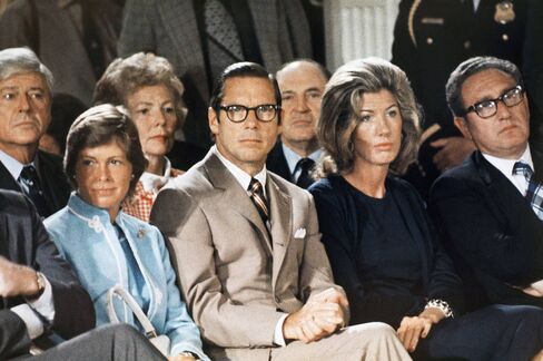 Treasury Secretary William Simon, left, sits with Nancy Kissinger and Secretary of State Henry Kissinger as they listen to former President Nixon talk to his staff prior to leaving the White House for the last time, August 9, 1974.
