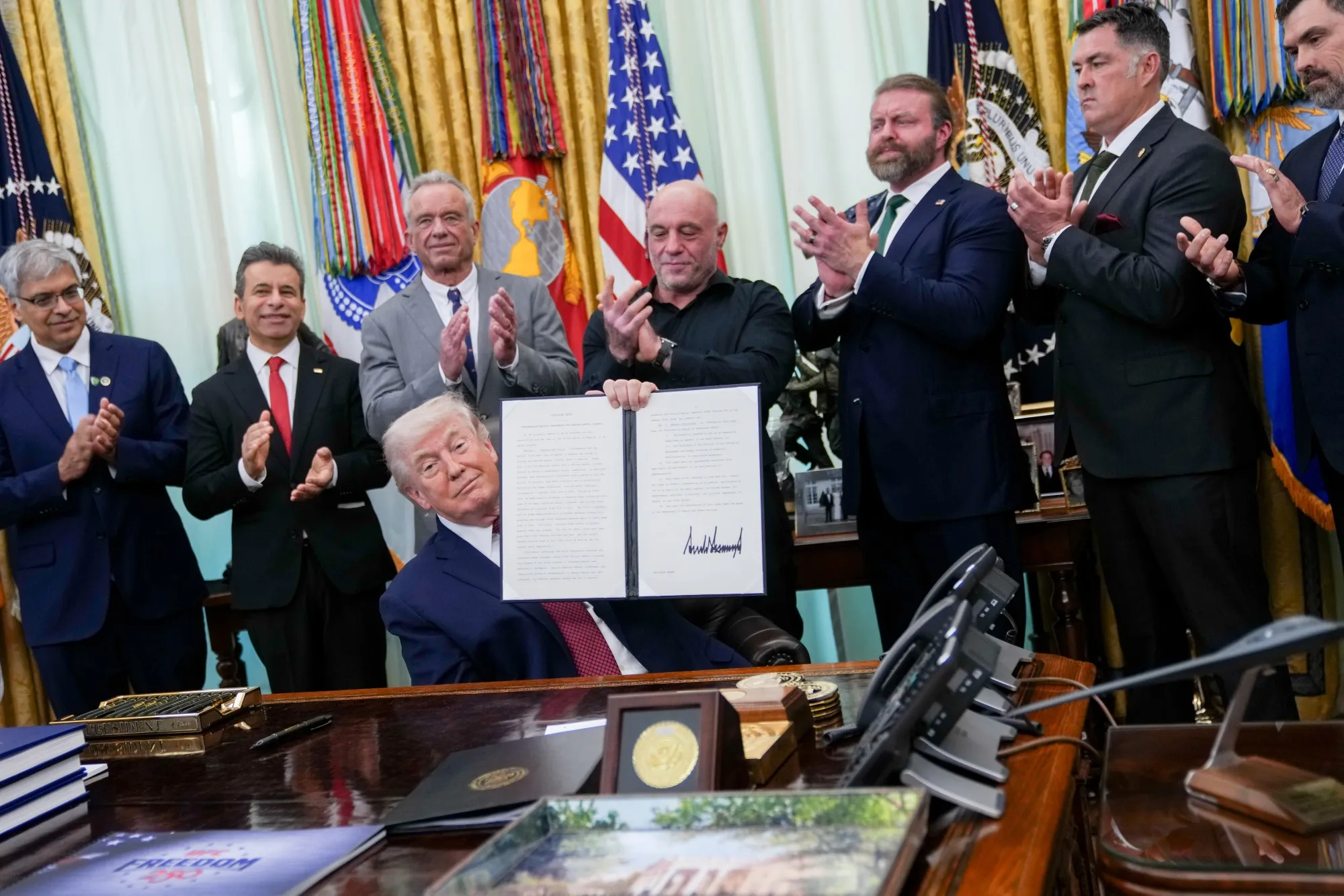 President Donald Trump displays a signed executive order in the Oval Office of the White House in Washington on April 18.