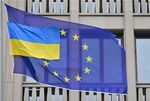 A smaller Ukrainian flag flies next to a flag of EU in front of the EU-representation office in Berlin.