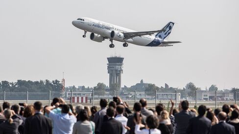 Spectators watch as an Airbus A320neo aircraft manufactured by Airbus Group NV takes off on its debut flight at Toulouse-Blagnac airport in Toulouse, France, on Sept. 25, 2014.