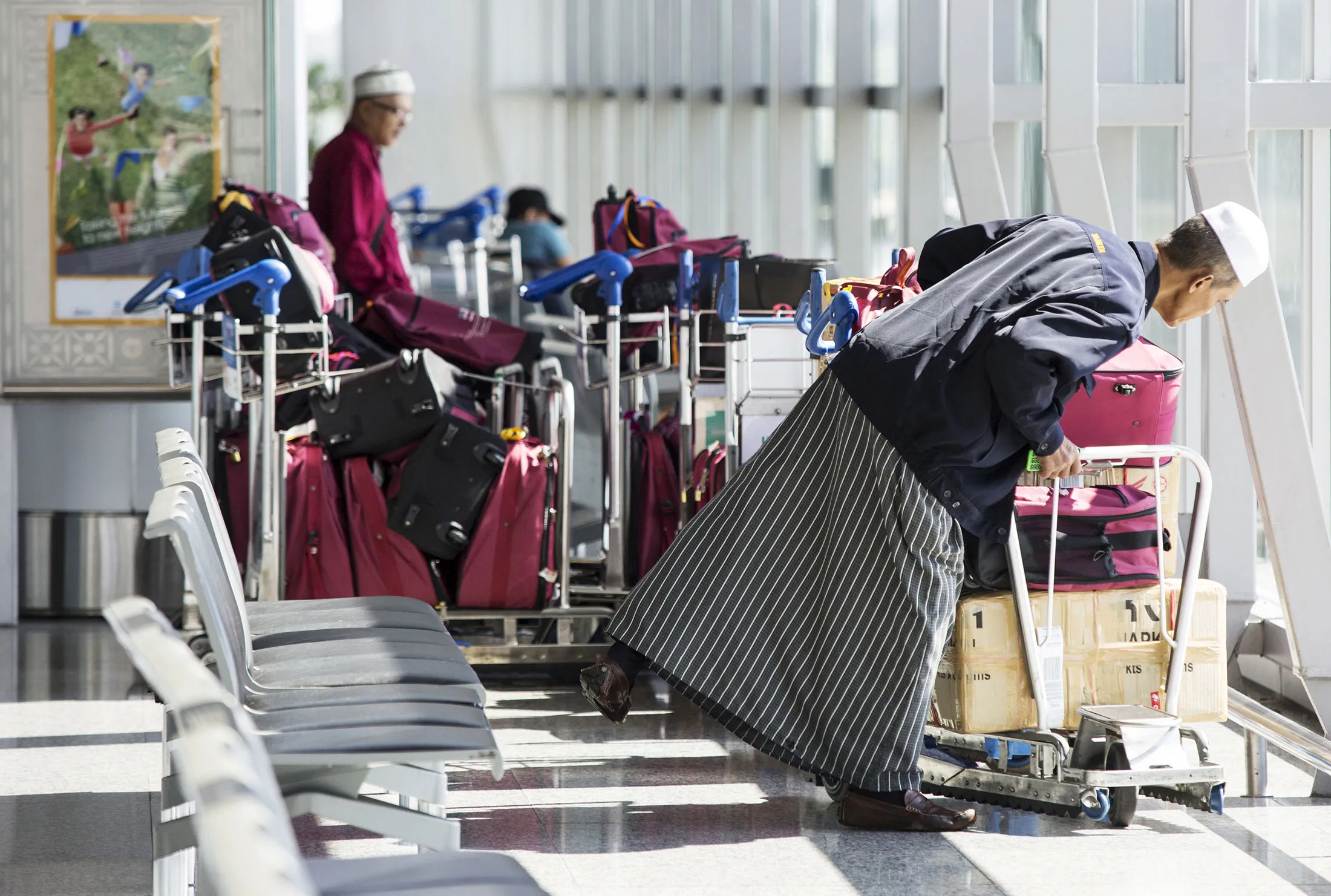 A passenger looks at his luggage on a trolley at Kuala Lumpur International Airport (KLIA) in Sepang, Malaysia.
