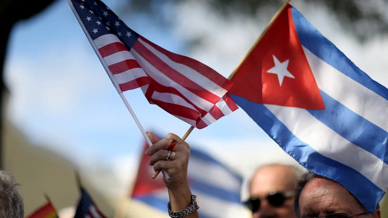 A protester holds American and Cuban flags on Dec. 20, 2014, in Miami.

