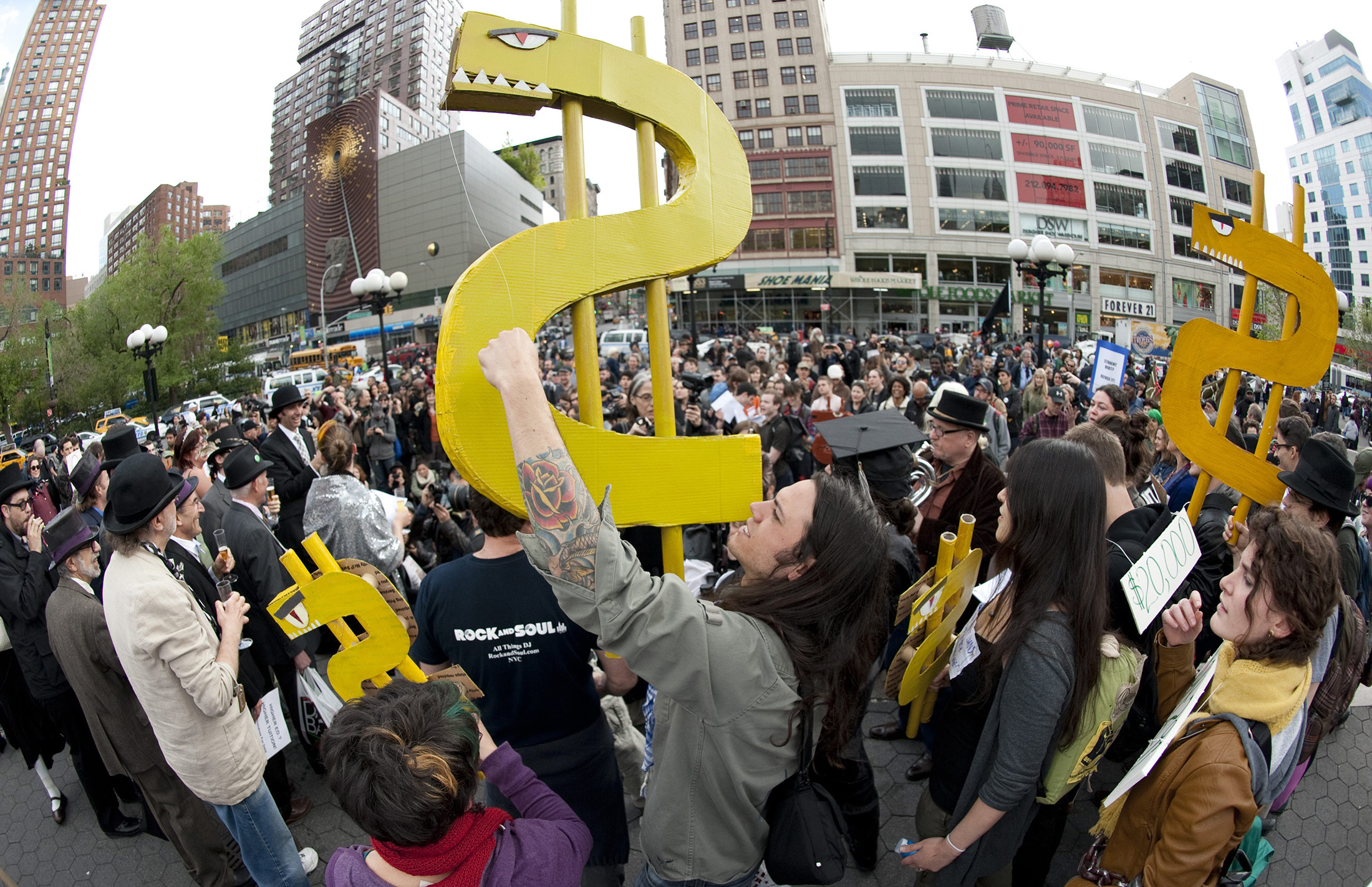 Protesters hold dollar signs during an Occupy Wall Street rally in New York against the high cost of college tuition, in 2012.
