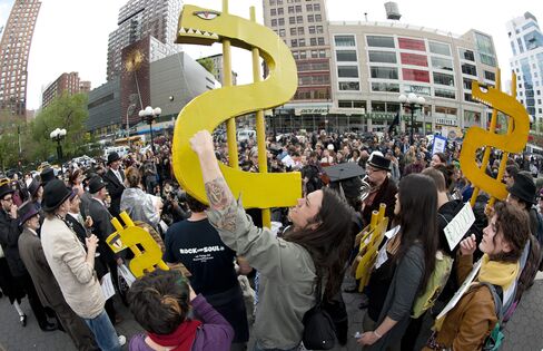 Protesters hold dollar signs during an Occupy Wall Street rally in New York against the high cost of college tuition, in 2012.