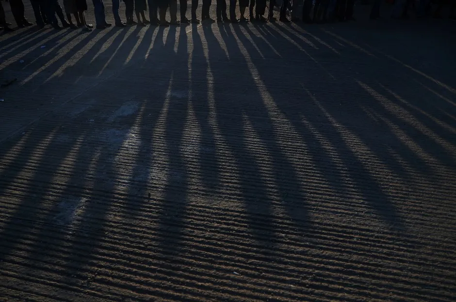 A group of migrants line up to receive food donations in a makeshift camp in Juchitan, Mexico.