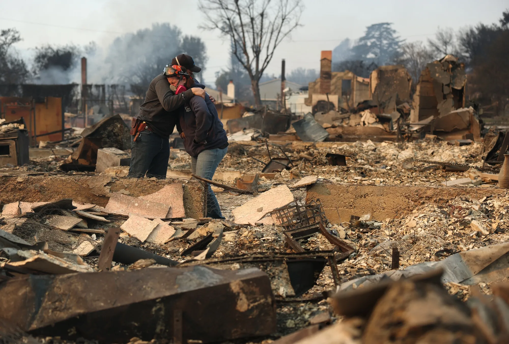 Residents embrace amid&nbsp;the ruins of a home in Altadena, California.