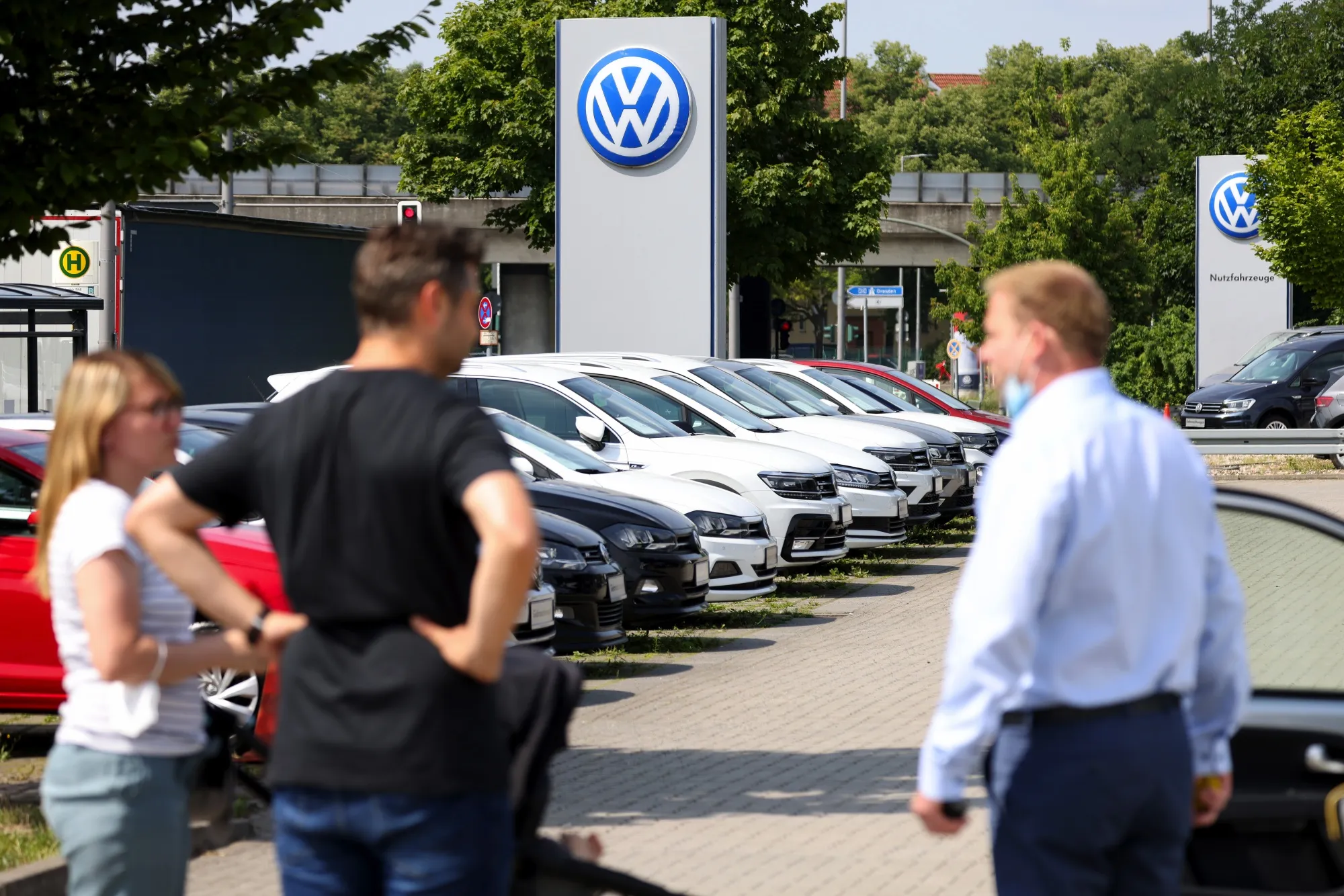 Customers with a salesperson on the forecourt of a Volkswagen AG&nbsp;showroom in Berlin.