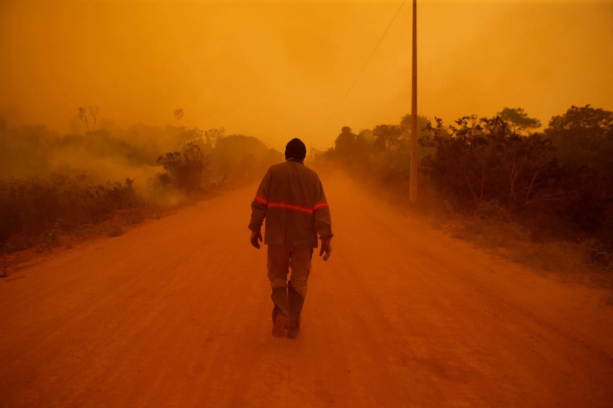 A volunteer firefighter walks along Transpantaneira road at the Pantanal wetlands region in Porto Jofre city, Mato Grosso state, Brazil, on Friday, Sept. 11, 2020. 
