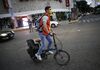A volunteer wearing a dust mask rides a bike in the Roma neighborhood of Mexico City, Wednesday, September 20, 2017.