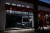 Pedestrians walk past a closed Tesla Inc. store in Palm Desert, California, U.S., on Thursday, March 7, 2019. Tesla has cut prices of the Model 3 and its other vehicles several times this year to offset the lower incentives, most recently by announcing a plan to close most stores and shift all ordering online.