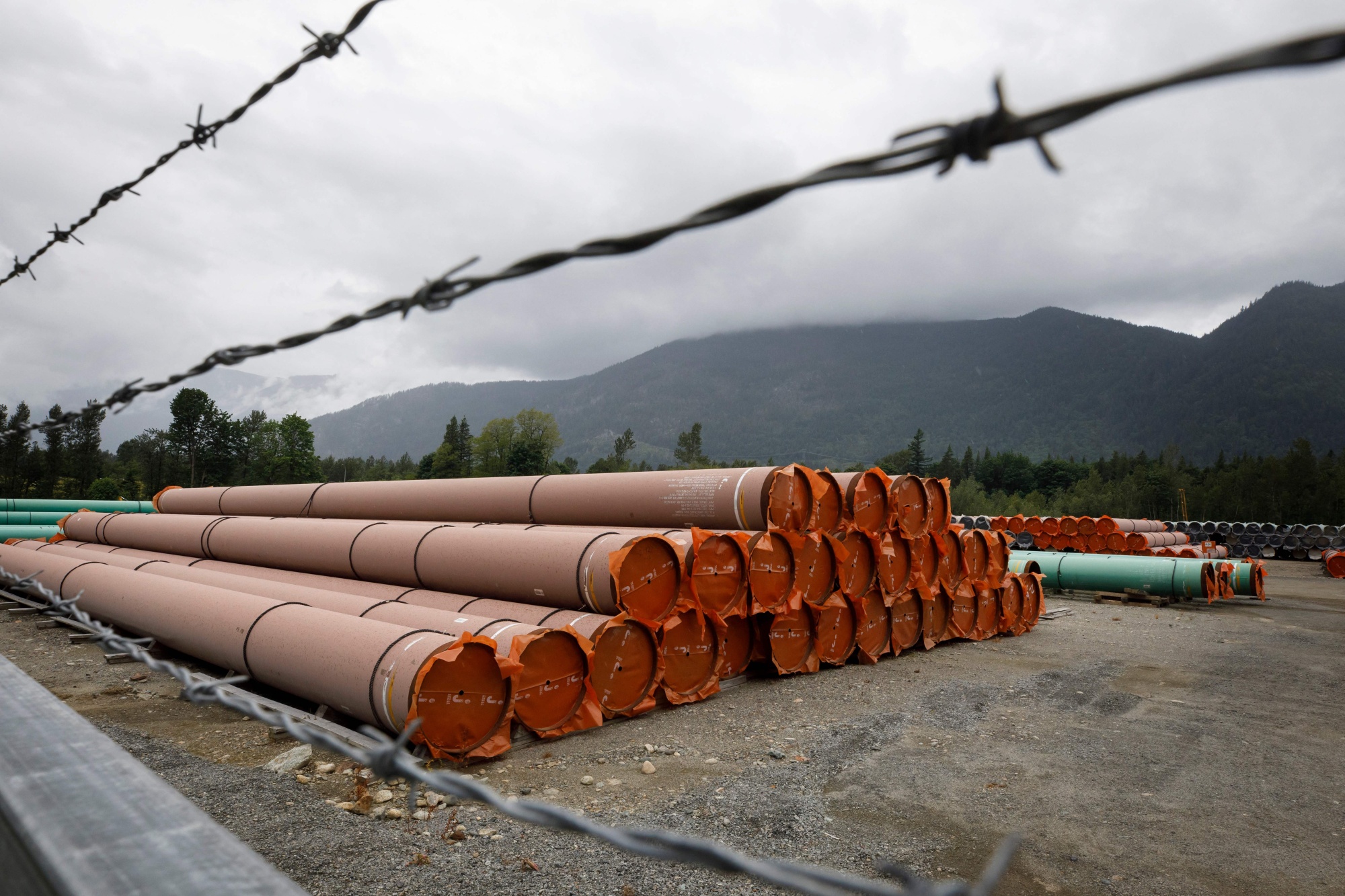 Pieces of the Trans Mountain pipeline project sit in a storage lot outside of Hope, British Columbia, during construction in 2021.