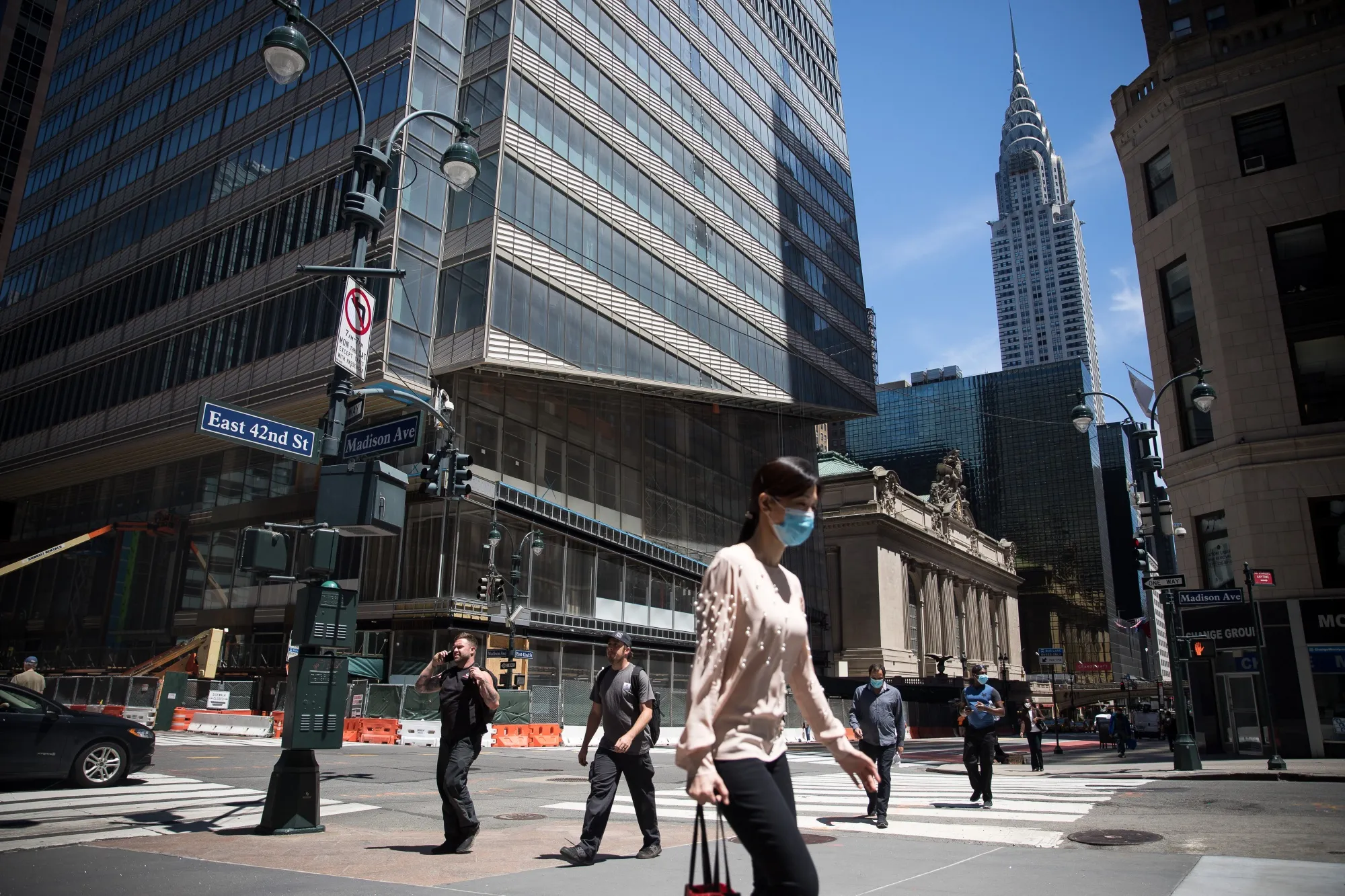A pedestrian wearing a protective mask walks past One Vanderbilt in New York.