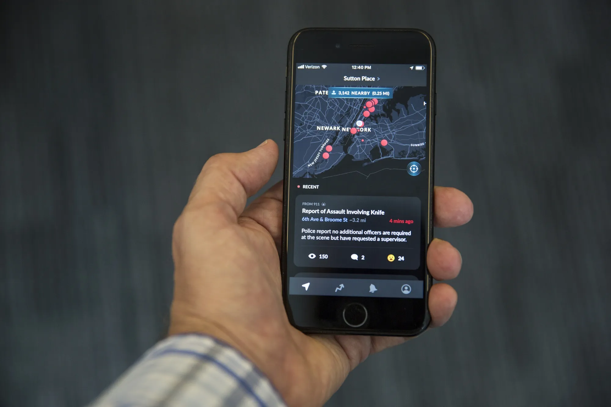 The Citizen application is displayed on an iPhone in an arranged photograph.