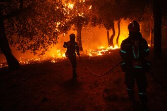 Firefighters tackle a wildfire northeast of Athens, Greece on July 9.