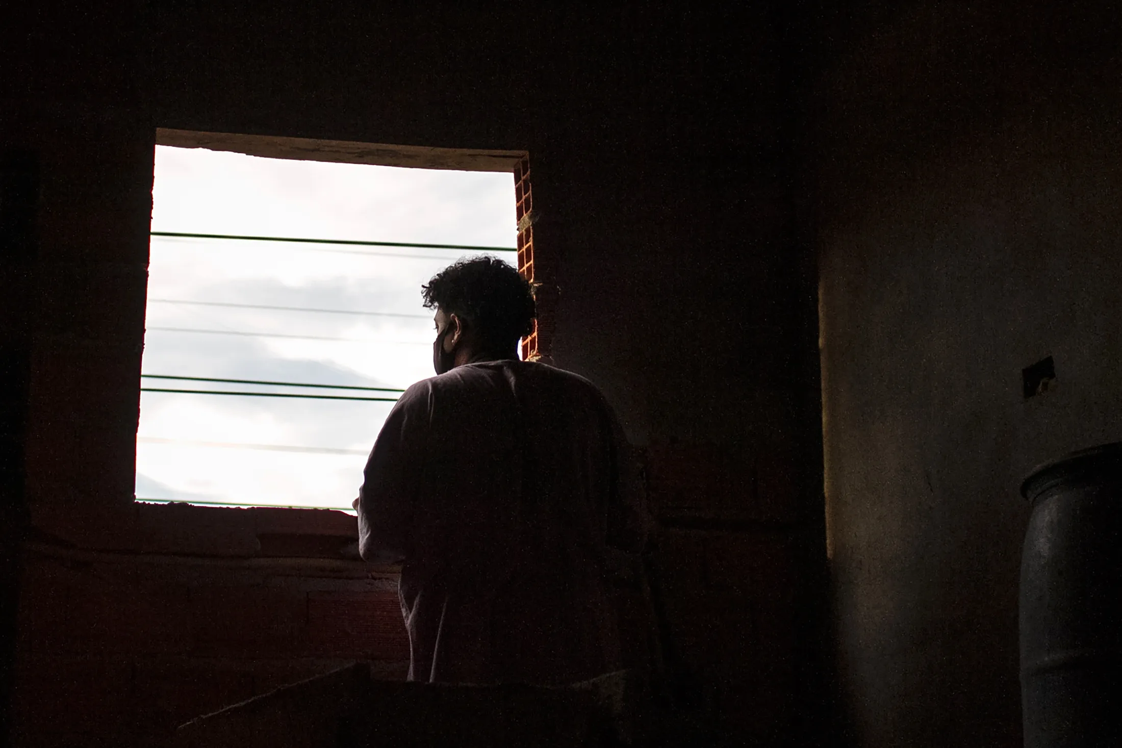 A resident observes a passing train from a window in the Favela do Moinho of Sao Paulo, on June 25.