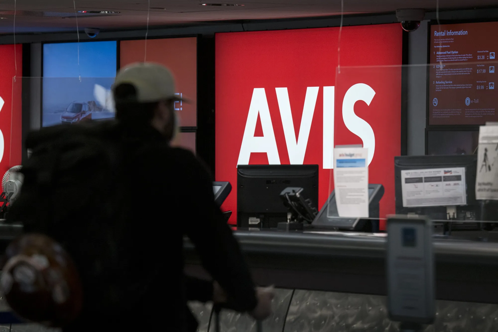 A customer waits at an Avis rental counter.