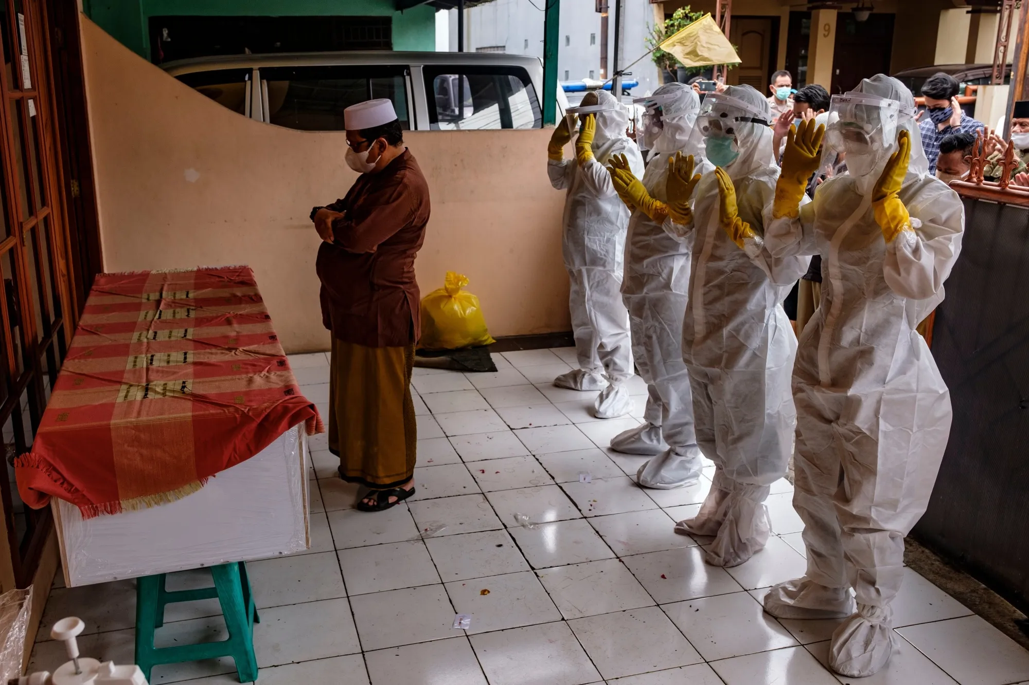 Members of a squad of public safety officers offer prayers in front of the casket of a person suspected to have died of Covid-19 in Jakarta, on July 13. 
