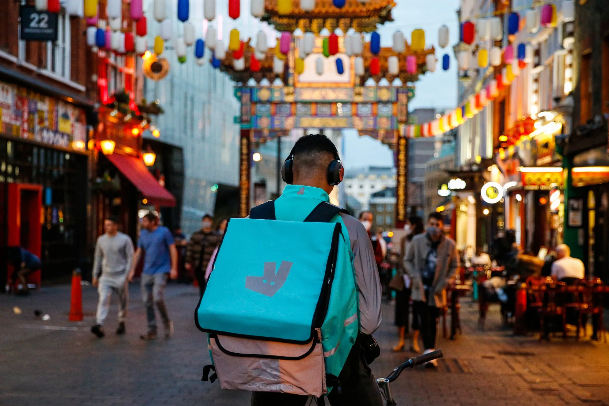 A Deliveroo courier stops in Chinatown, London.&nbsp;