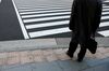 A morning commuter waits to cross a road in front of Tokyo Station in Tokyo, Japan, on Jan. 4, 2019. Japanese stocks dropped on the first trading day of 2019, as Apple Inc.’s outlook cut and weak economic data from the U.S. and China intensified global growth concerns.