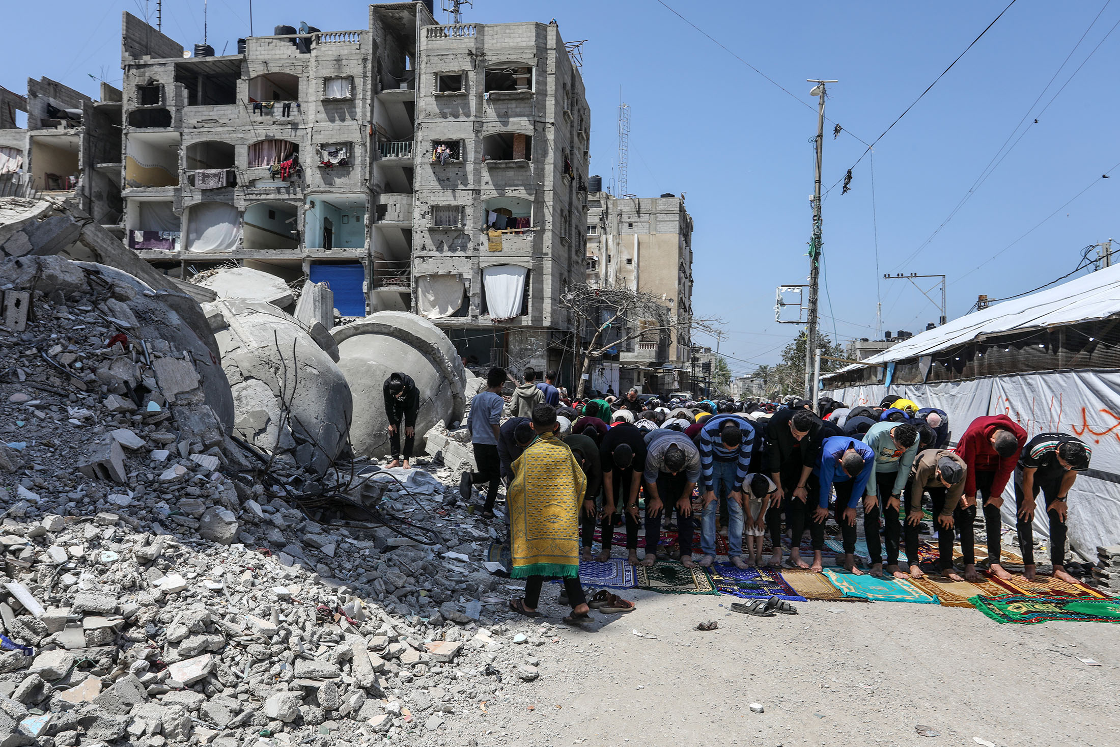 Muslims perform Friday prayer among the rubble of Al-Farooq Mosque in Rafah, Gaza on April 12, 2024