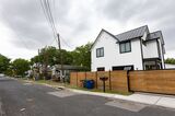 A new home, right, towers over residences on the same street in the Montopolis neighborhood of Austin in 2022. The booming Texas capital's efforts to revise its land development code and build more affordable housing have been thwarted by protests from homeowners.