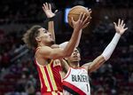 Atlanta Hawks guard Trae Young, left, shoots over Portland Trail Blazers guard Anfernee Simons during the first half of an NBA basketball game in Portland, Ore., Monday, Jan. 3, 2022. (AP Photo/Craig Mitchelldyer)