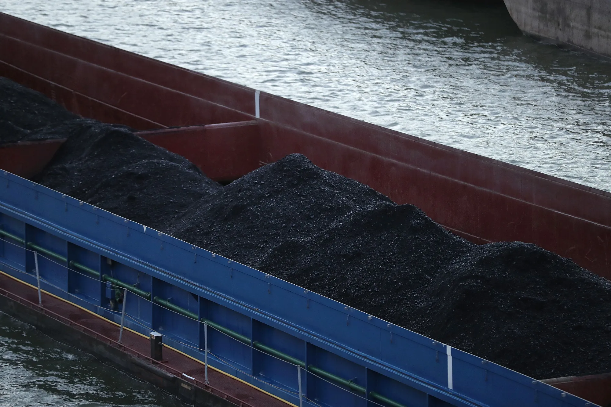 A barge transporting coal sails past the Volkswagen AG&nbsp;headquarters on the Mittleland canal in Wolfsburg, Germany.