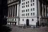 A trader walks in front of the New York Stock Exchange.