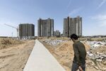 A worker walks towards residential buildings under construction in Qingdao, China.