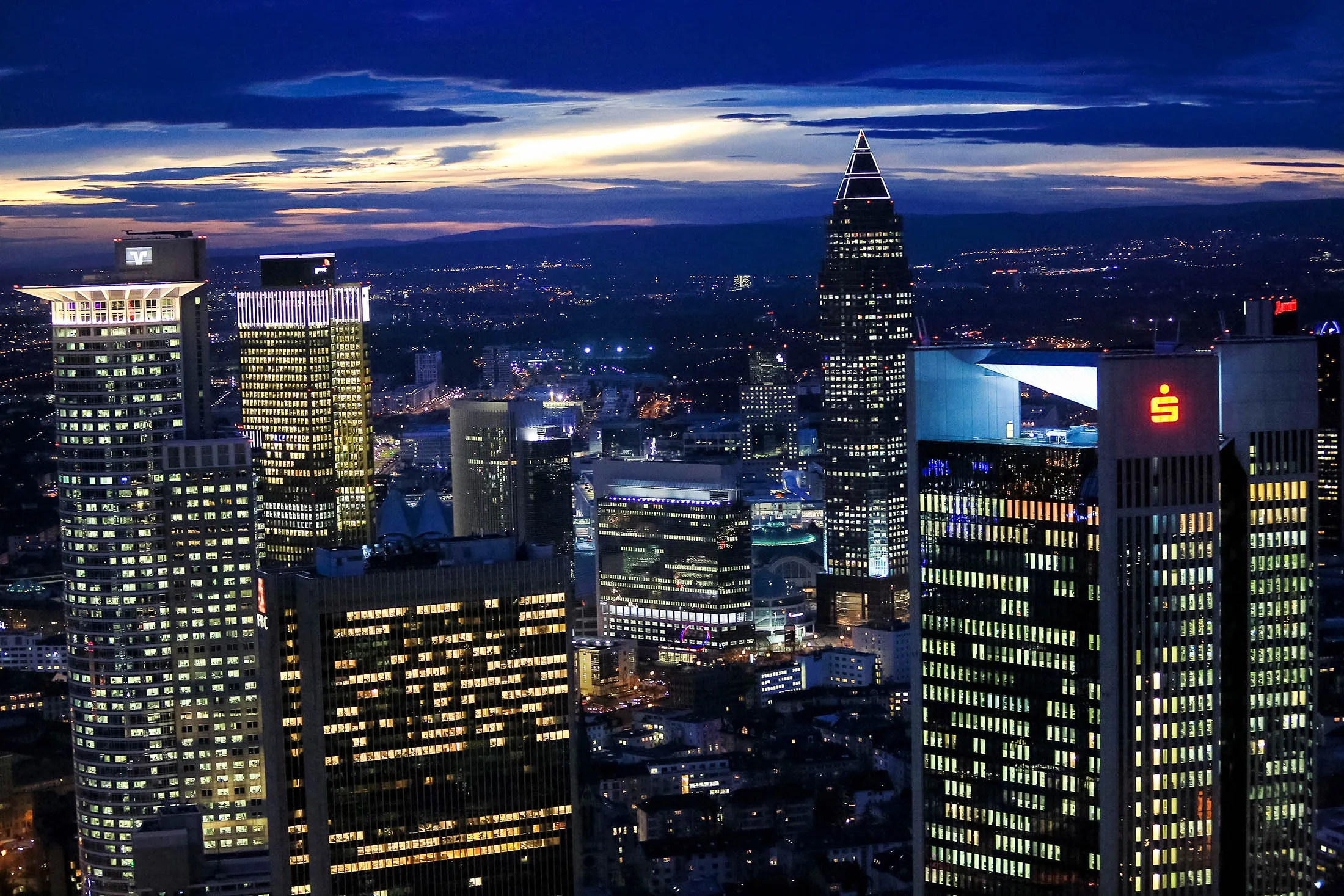 Skyscrapers stand illuminated on the city skyline at dusk in Frankfurt, Germany, on Wednesday, Jan. 27, 2016. German domestic demand, buoyed by a stable labor market and low oil prices, will propel the country's economic growth this year and compensate for slowing exports as emerging economies stumbles.

