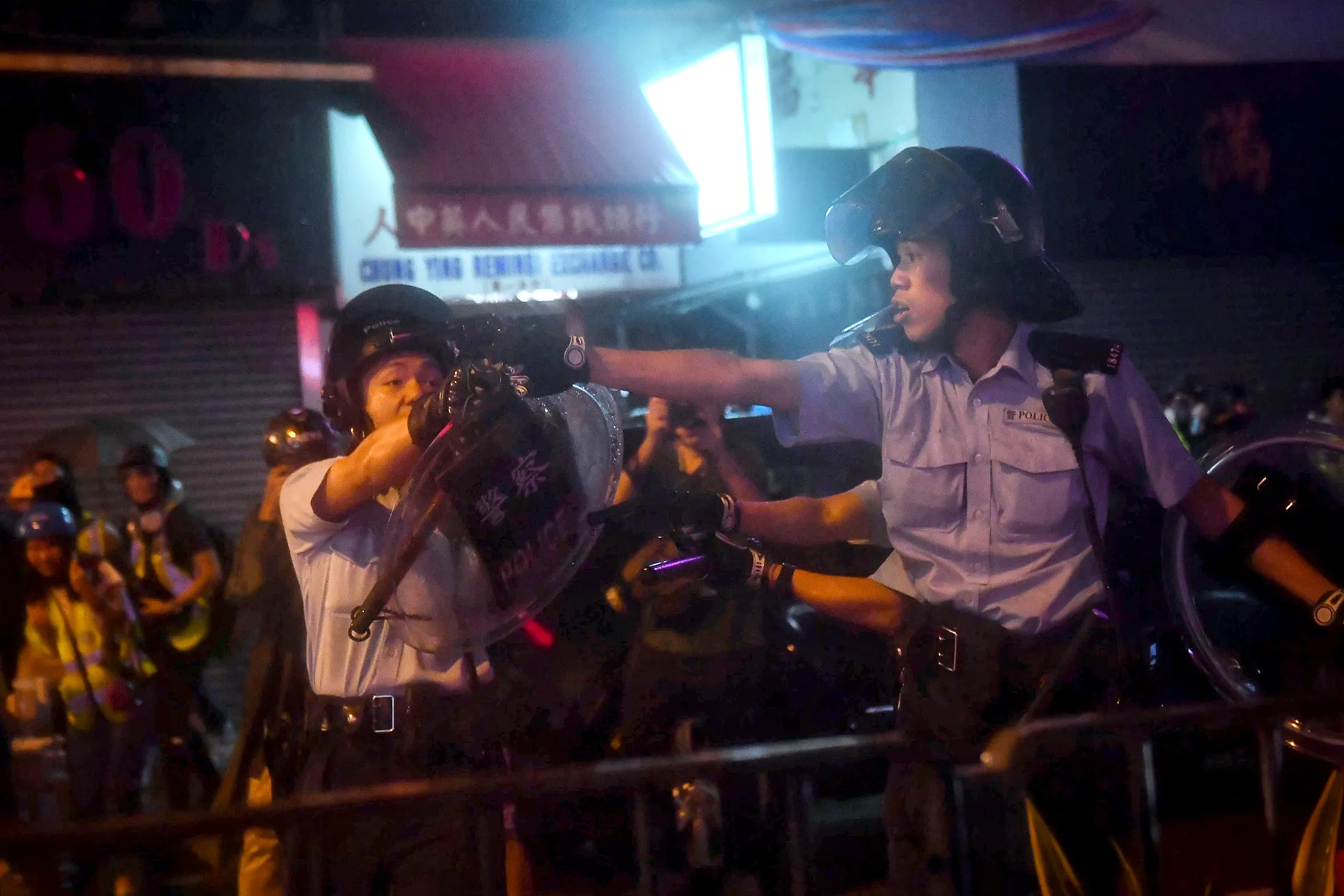 Police officers point their guns at protesters in Tseun Wan in Hong Kong on Aug.&nbsp;25
