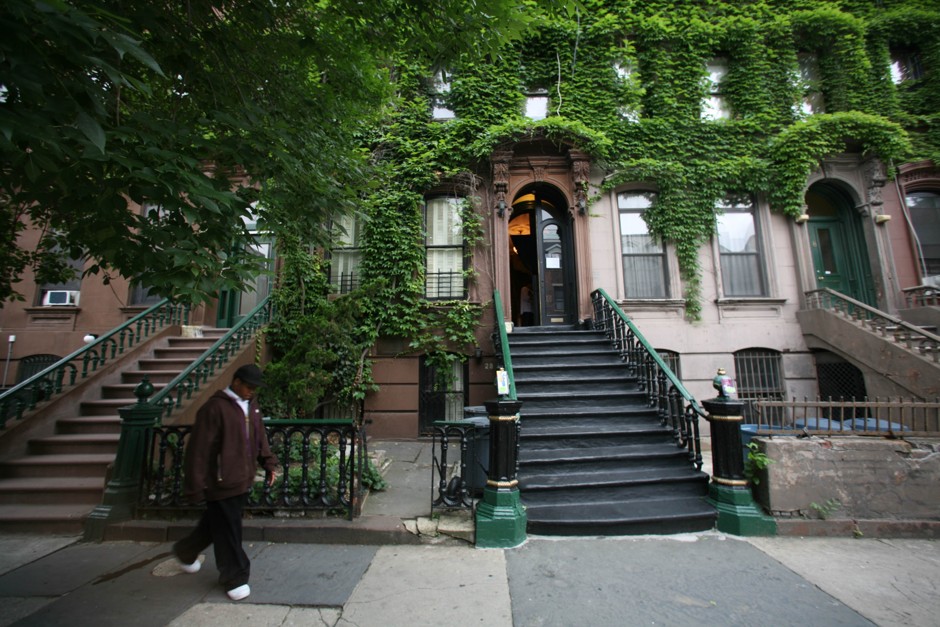 A youth walks by the Langston Hughes House, center, in Harlem.