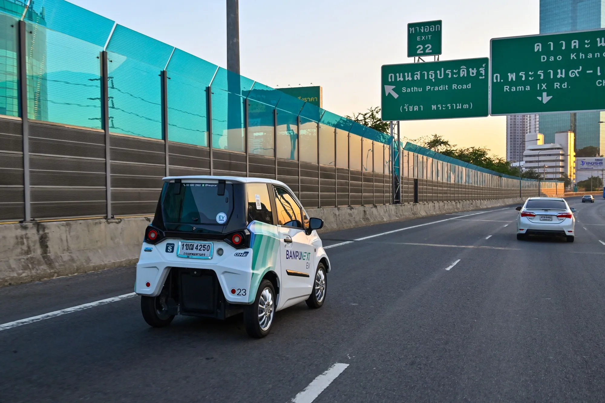 A mini electric vehicle&nbsp;drives along a road in Bangkok.
