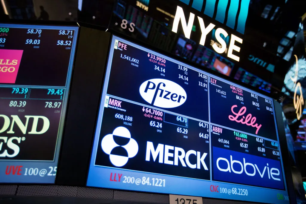 A monitor displays signage for Pfizer Inc., Eli Lilly and Co., AbbVie Inc. and Merck & Co Inc. on the floor of the New York Stock Exchange (NYSE) in New York, U.S., on Monday, March 13, 2017. U.S. stocks held steady as they kicked off a week dominated by central-bank updates including the Federal Reserve's rate decision.