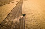 A farmer operates a combine harvester during a wheat harvest at a farm in New South Wales, Australia.