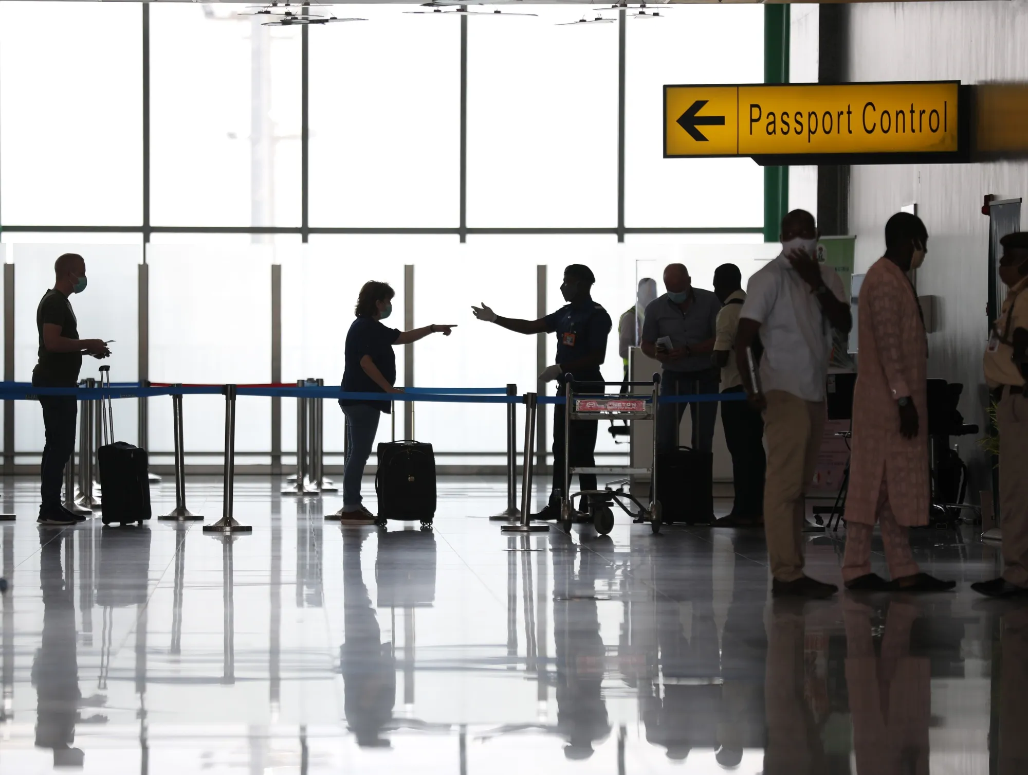 Passengers wait in line at the departure terminal of the Nnamdi Azikiwe International Airport, in Abuja, Nigeria.