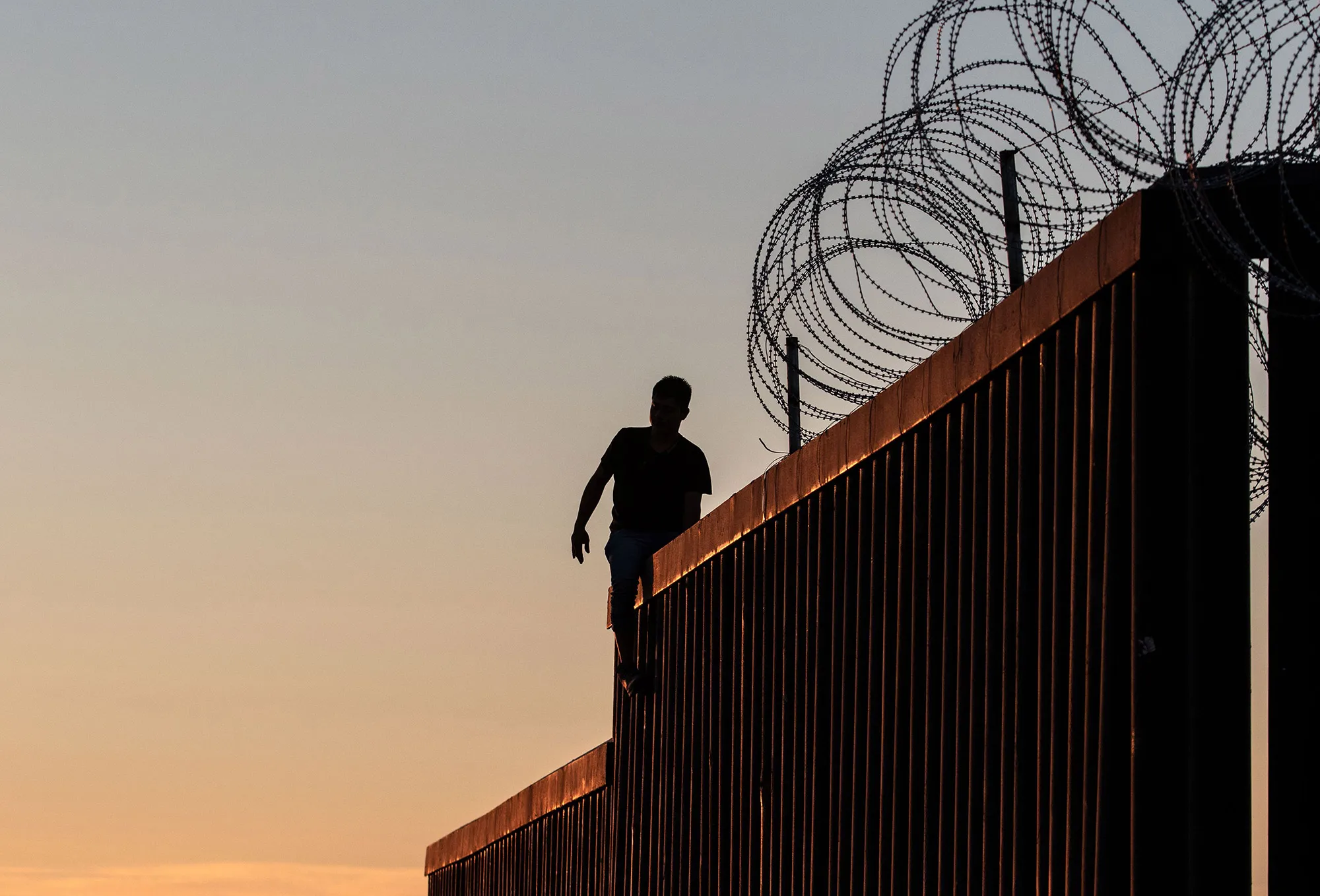 A man stands on the US-Mexico border wall&nbsp;in Playas de Tijuana,&nbsp;Mexico.&nbsp;