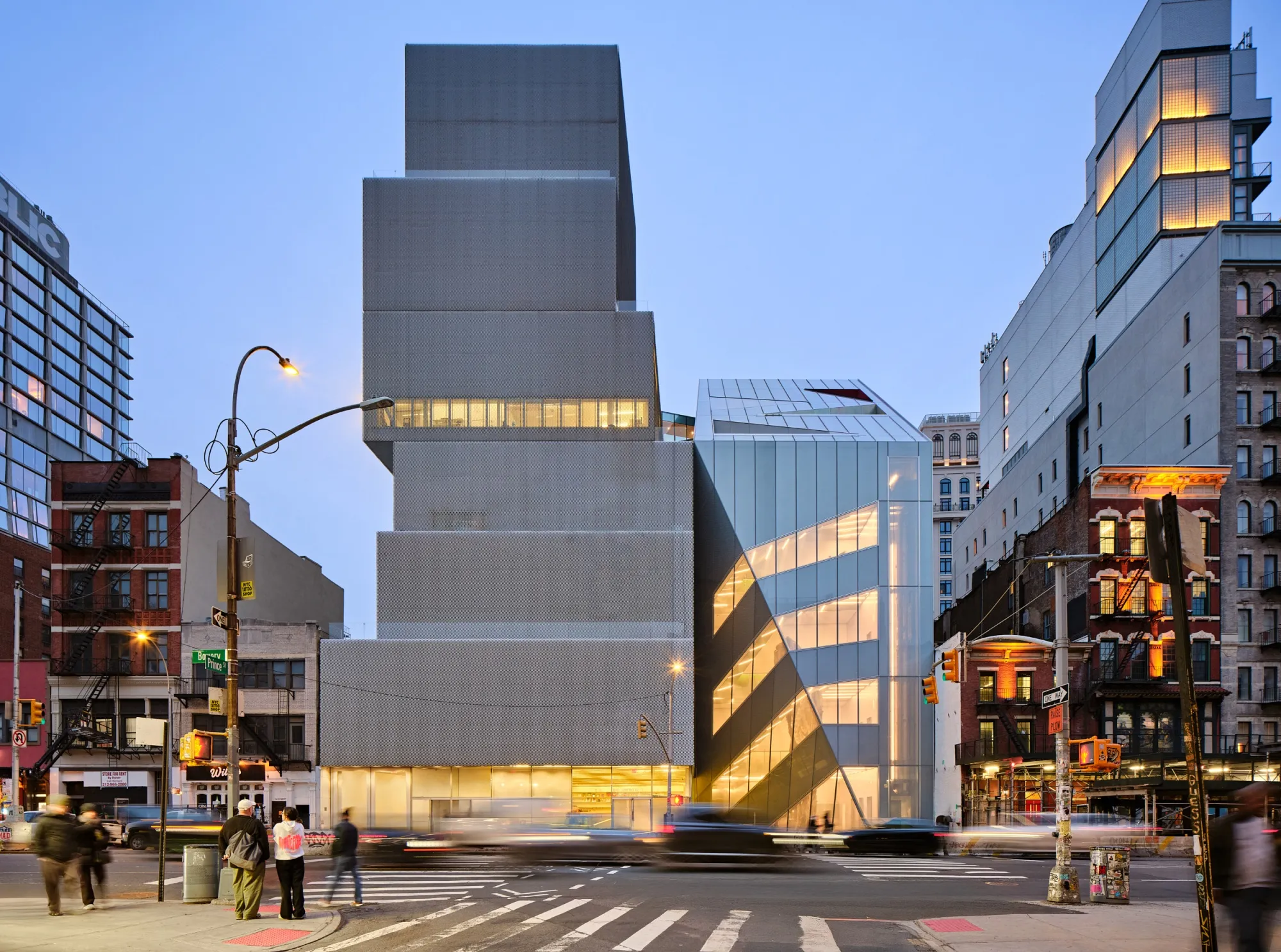 An expansion of the New Museum (right) designed by OMA contrasts the original building in more ways than one.
