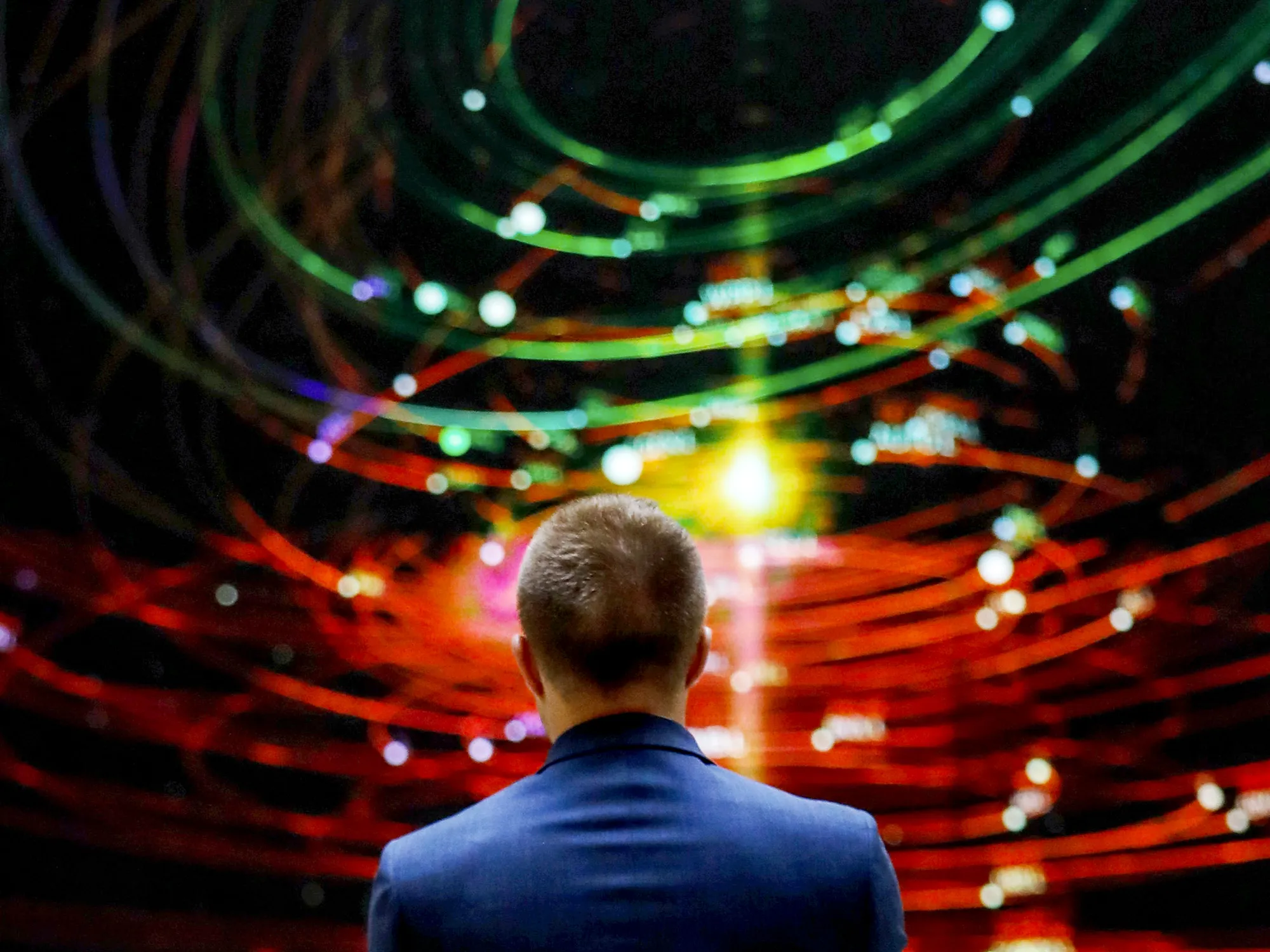 An employee views a FTSE share index board in the atrium of the London Stock Exchange.
