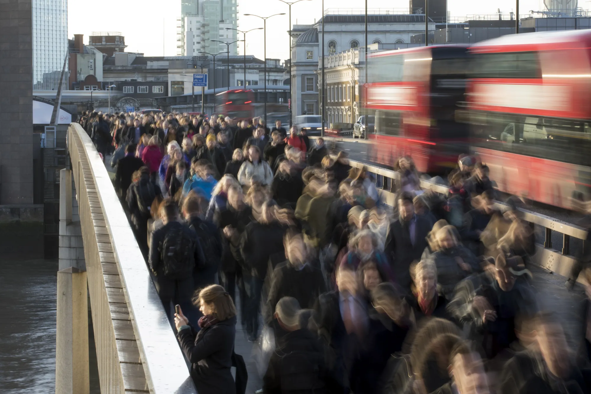 Commuters walk across London Bridge in London, U.K., on Monday, Dec. 18, 2017. U.K. firms wanting workers face the tightest labor market in two decades. In 2011, there were almost six unemployed people for every vacancy; now there are fewer than two, the lowest ratio since records began in 2001.