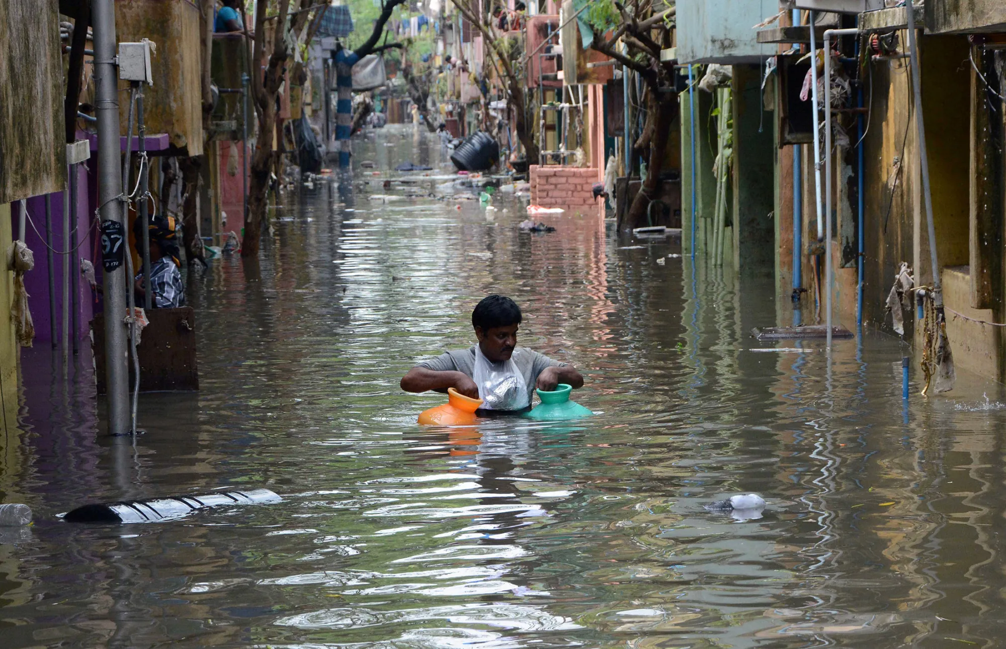 An man carries gas canisters through floodwaters on a street in Chennai, India, on Dec. 4.
